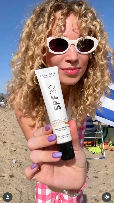 Creator presenting MADARA sunscreen on a sunny beach
